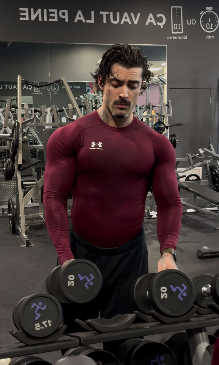 The coach is posing at the gym.